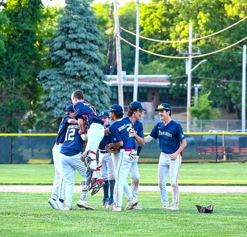 Reading Mariners players in navy uniforms celebrate on the field after the final out of the 2024 RBRL World Series.